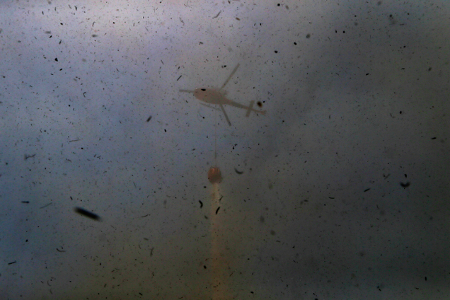 Debris kicked up by a helicopter dumping water onto a wildfire in Portezuelo, Chile on Jan. 29th, 2017. Image: AP Photo/Esteban Felix